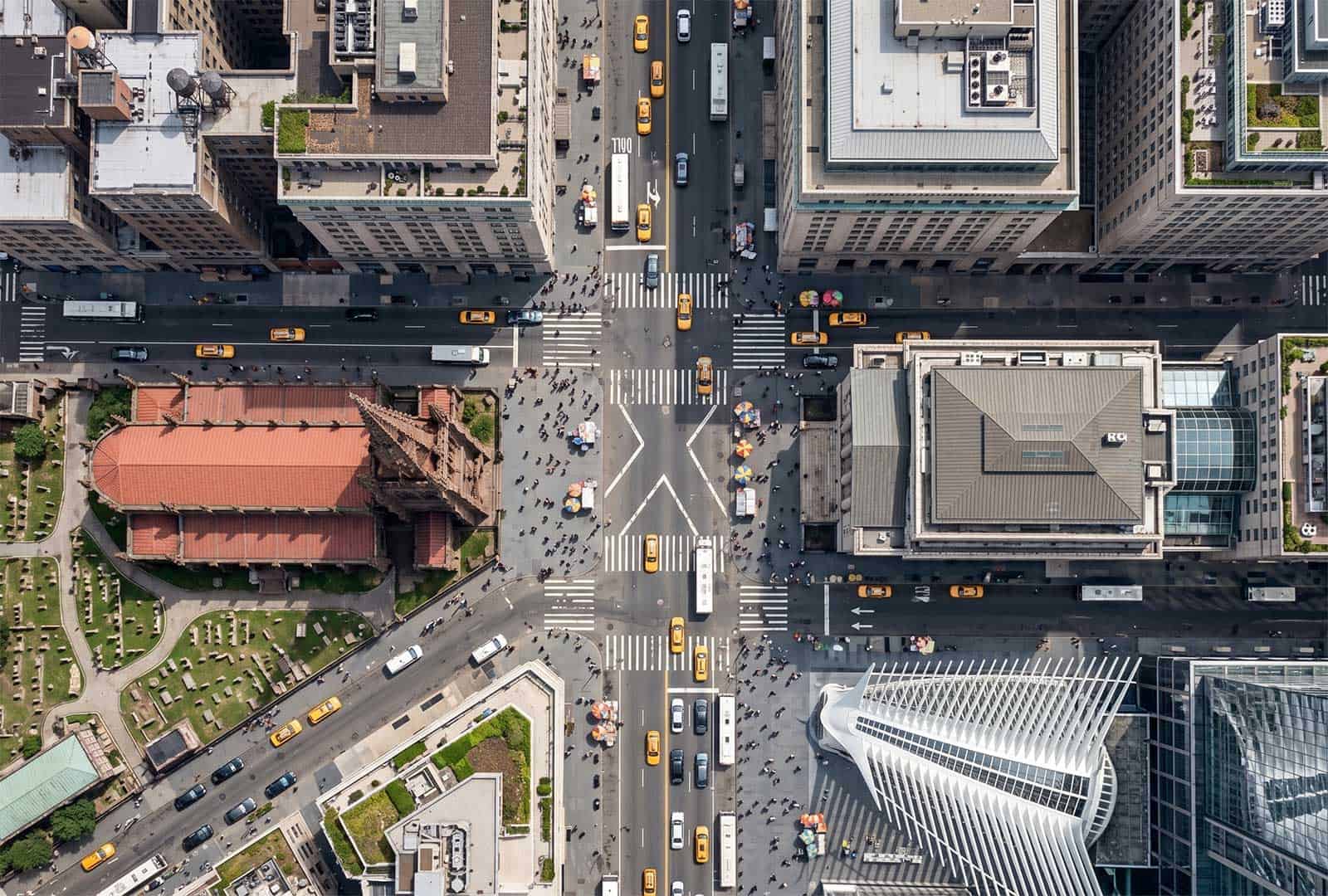 Autonomous vehicles navigating busy city streets at an intersection with modern buildings and traffi.