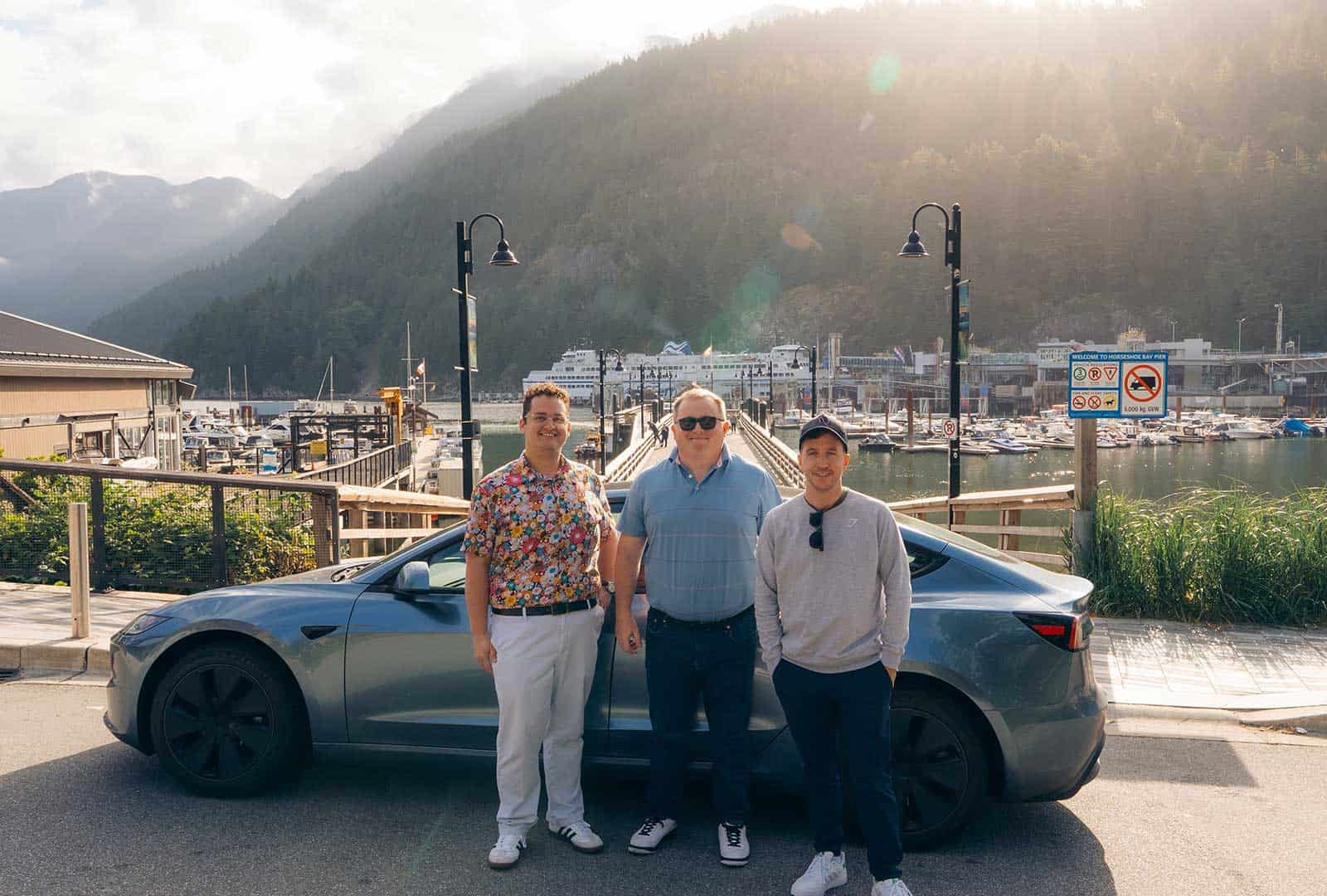 Tesla Model S with FSD in scenic Canadian harbor setting.