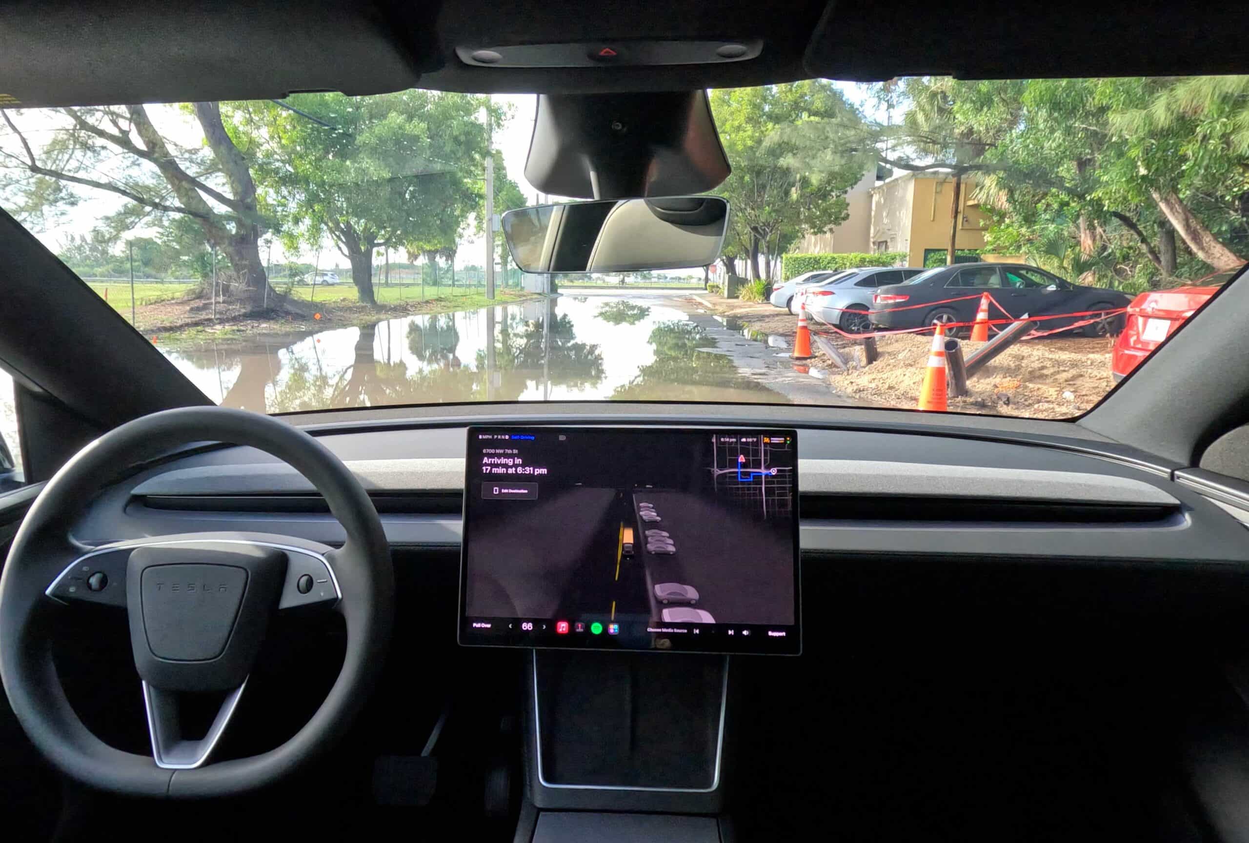 Interior view of an autonomous vehicle with a digital dashboard and road ahead.