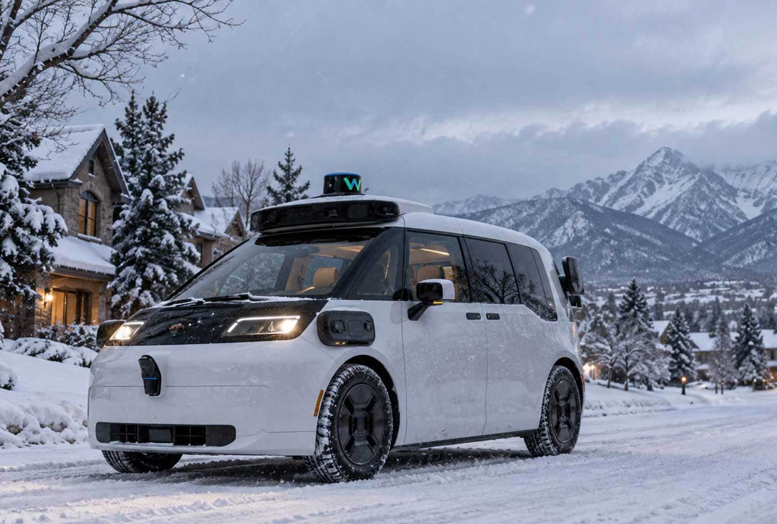 Waymo self-driving car navigating snowy mountain town landscape.
