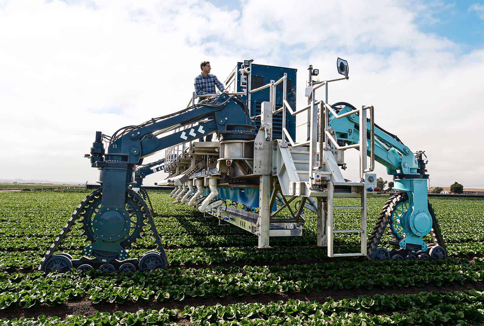 Autonomous farming robot operating in open fields with tracks and robotic arms.